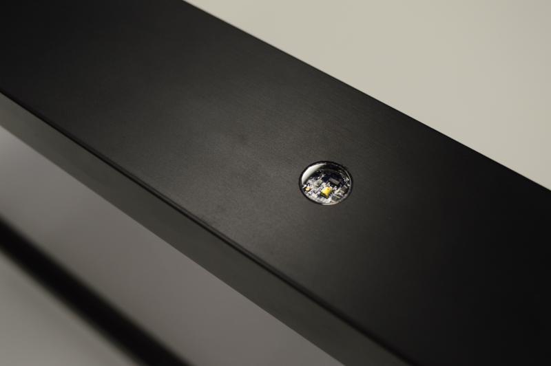 Close-up of circular acrylic disc installed in picture frame with light sensor mounted behind