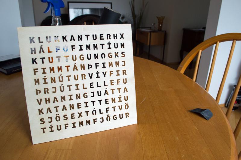 Laser cutter cutting an X into a piece of wood