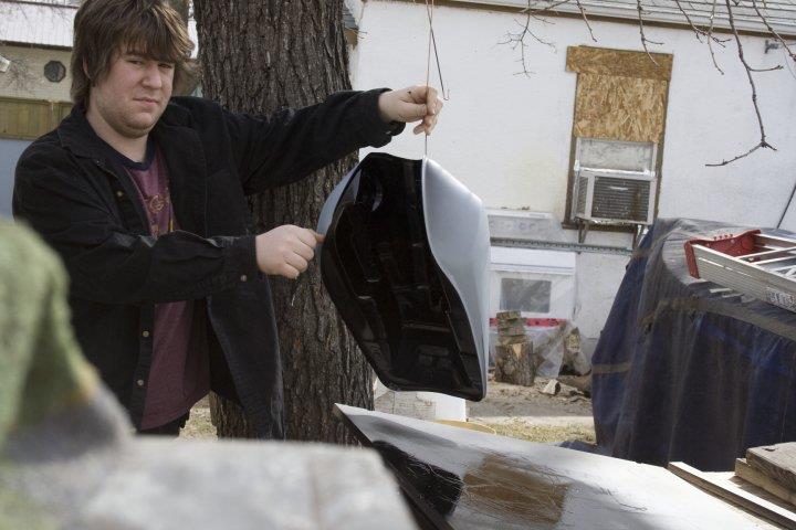 A grumpy James holding the primed gas tank out in the cold