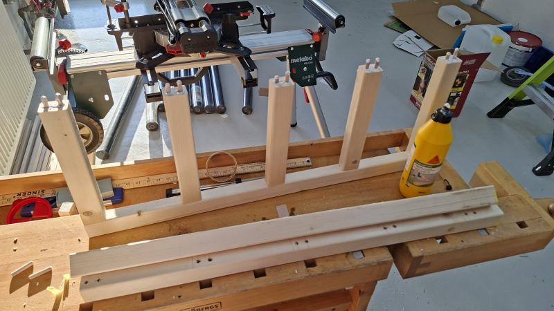 Side pieces pushed onto one leg with glue and dowels exposed on other side