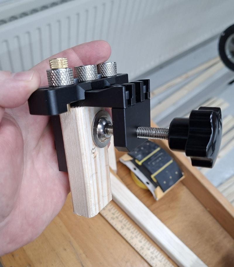 Dowel jig with slat off-cut mounted in it
