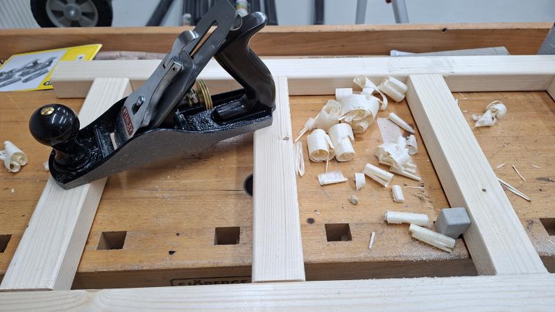 Side of shoe rack with plane and shavings